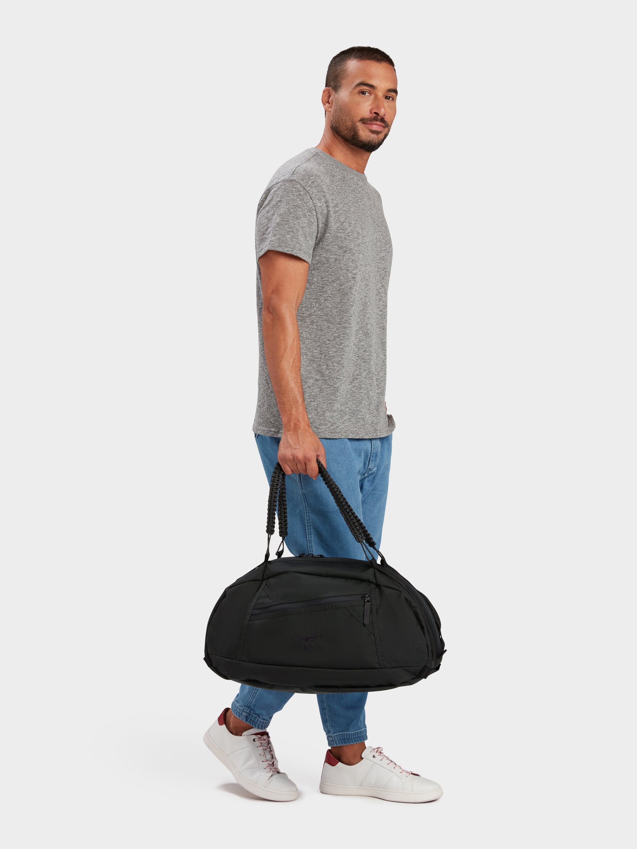 Grit duffle in black carried by model