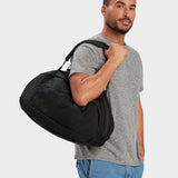 Grit duffle in black carried by model