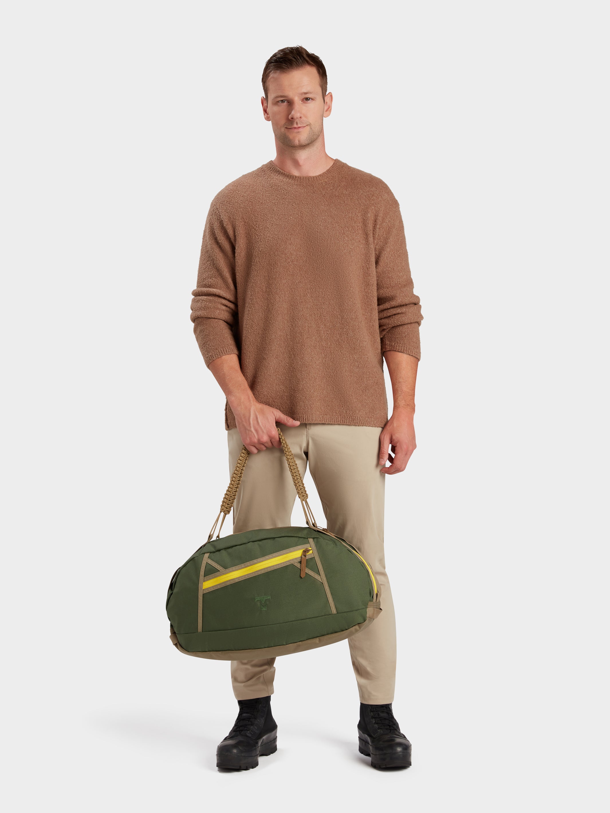 Grit duffle in camo green carried by model