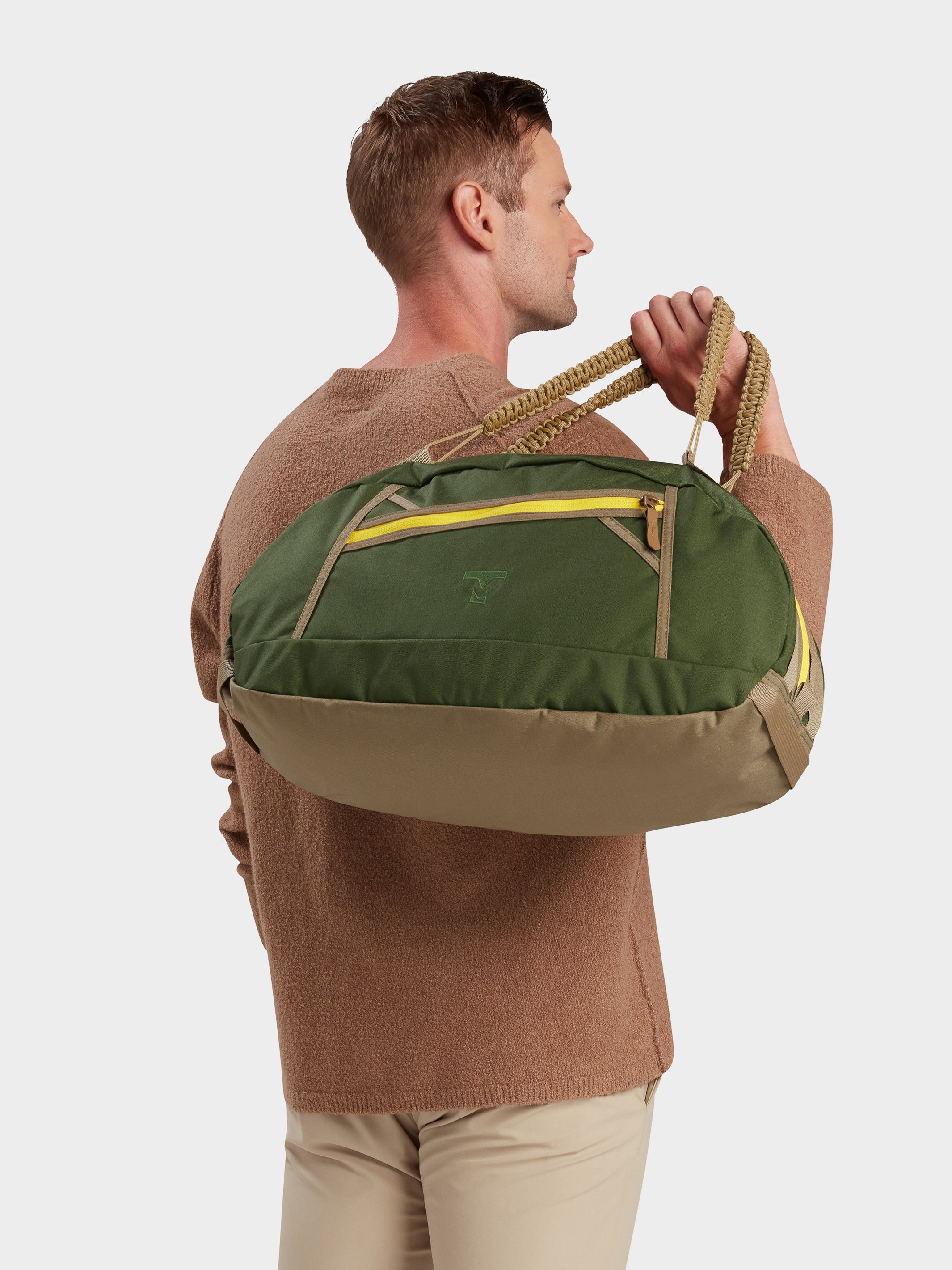 Grit duffle in camo green carried by model