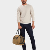 Grit duffle in coyote brown carried by model