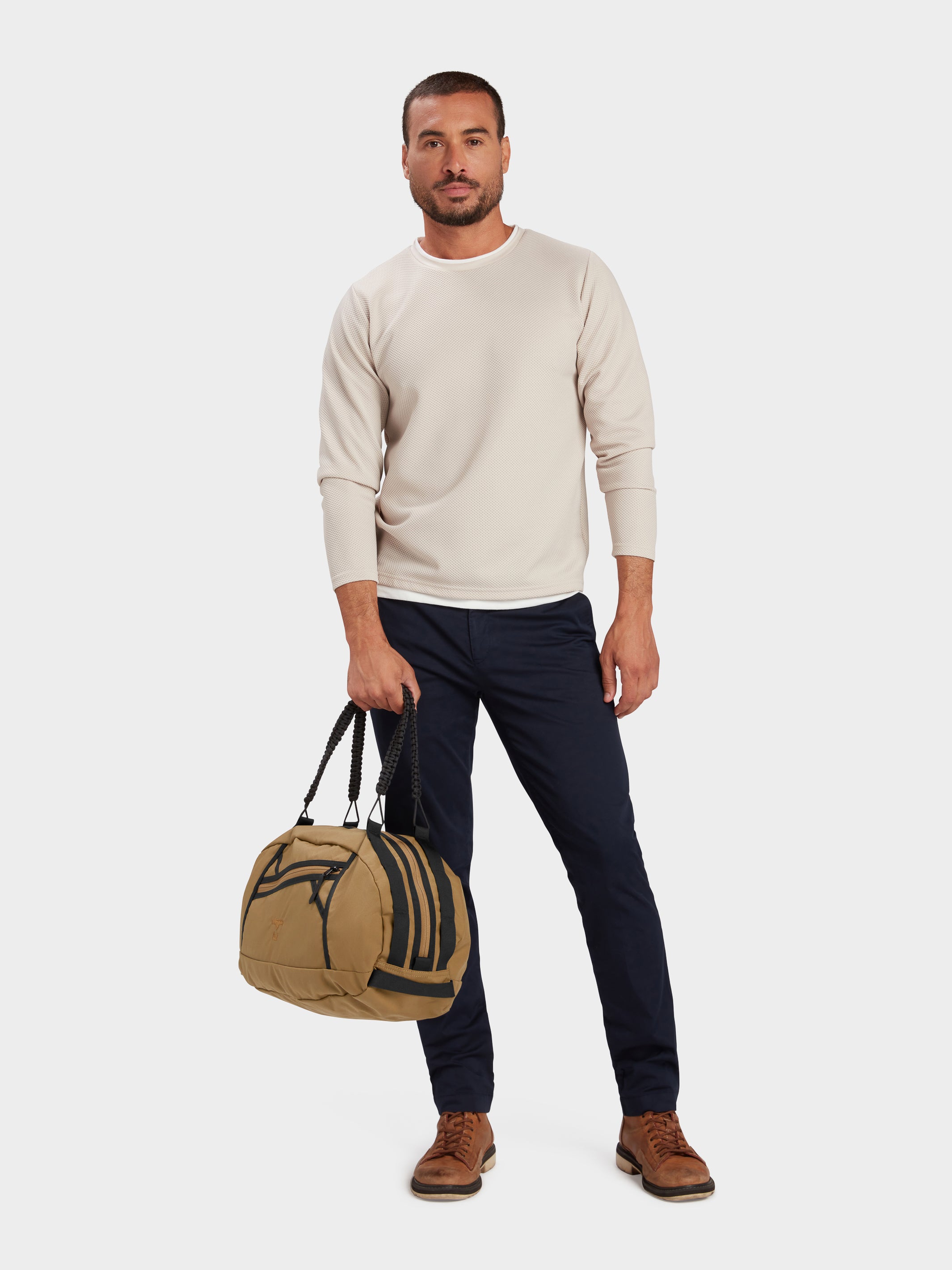 Grit duffle in coyote brown carried by model