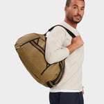 Grit duffle in coyote brown carried by model