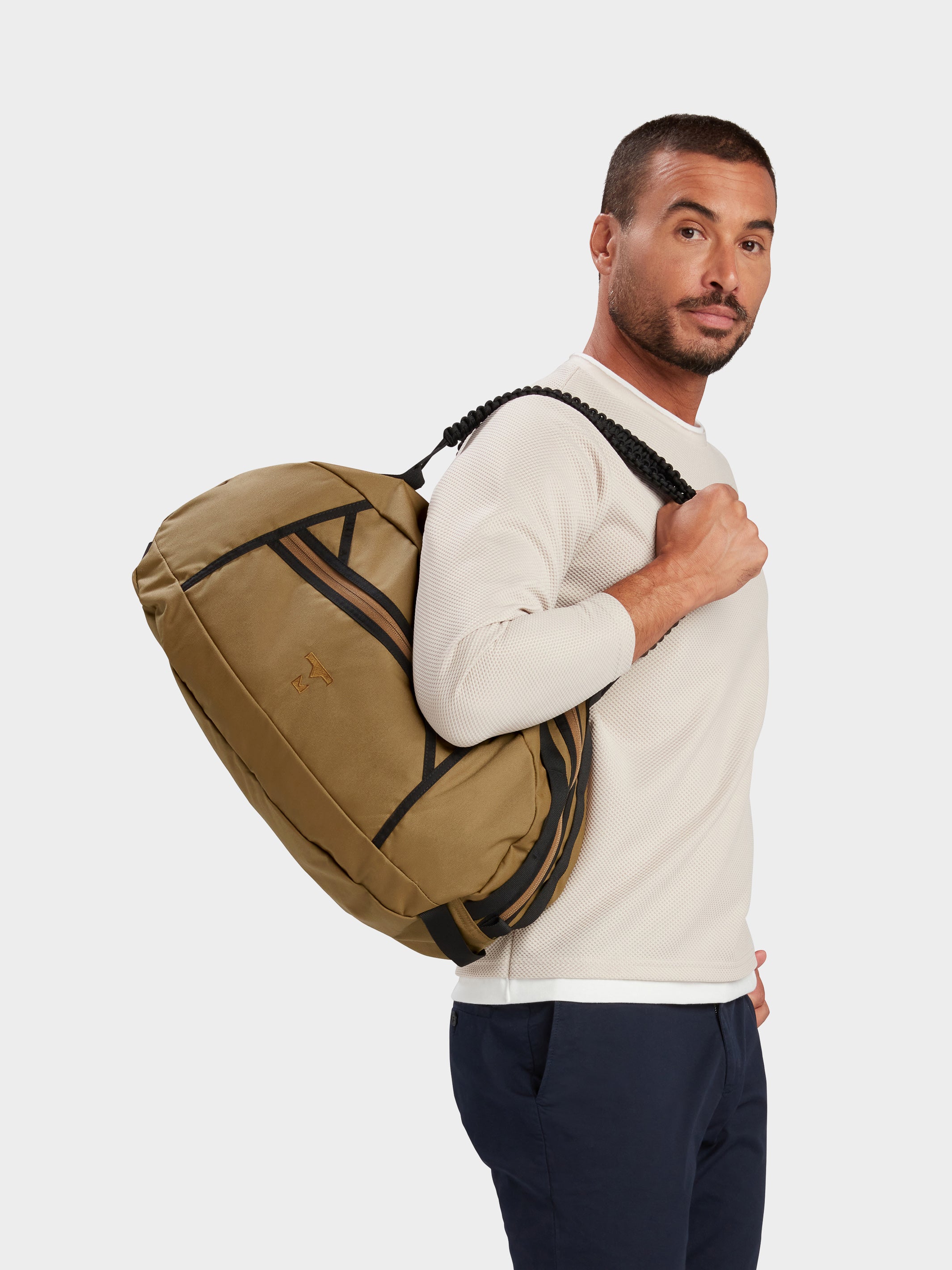 Grit duffle in coyote brown carried by model